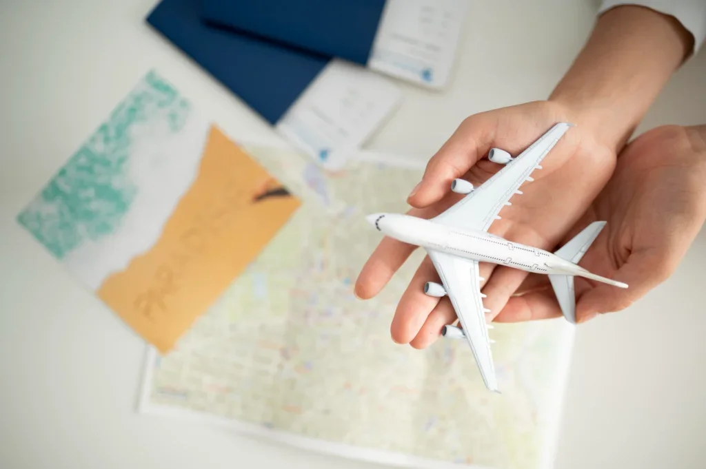 Agencia de viajes internacionales, manos con un avión blanco de plástico