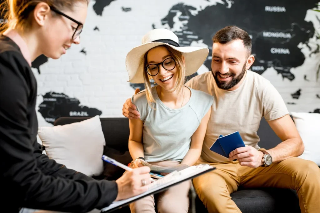 Pareja feliz planeando sus vacaciones en una agencia de viajes