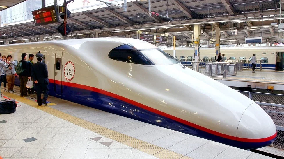 Estación del tren bala Shinkansen en Japón con pasajeros abordando.